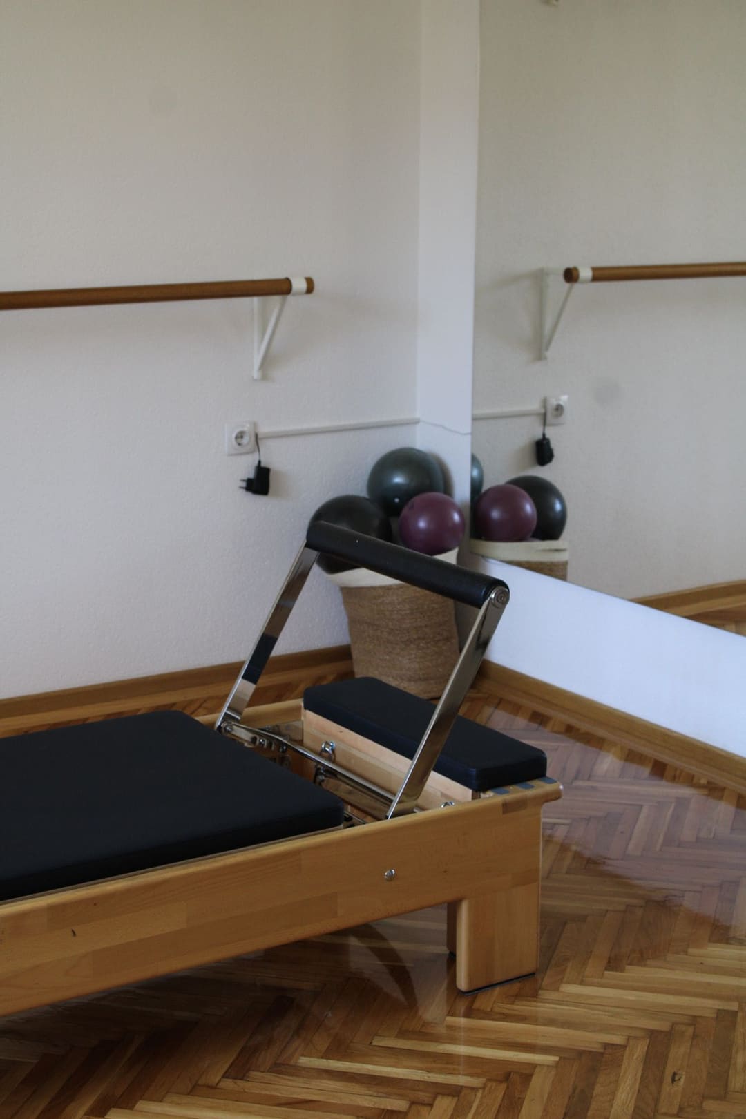Reformer od svetlog drveta sa crnim jastucima u studiju